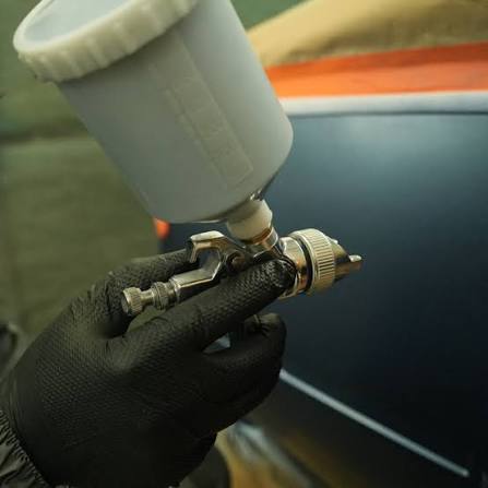 Lackierer arbeitet an der Fahrzeugkarosserie